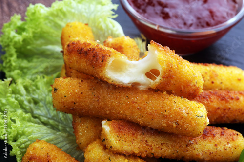 Breaded mozzarella cheese sticks with tomato ketchup and bbq sauce