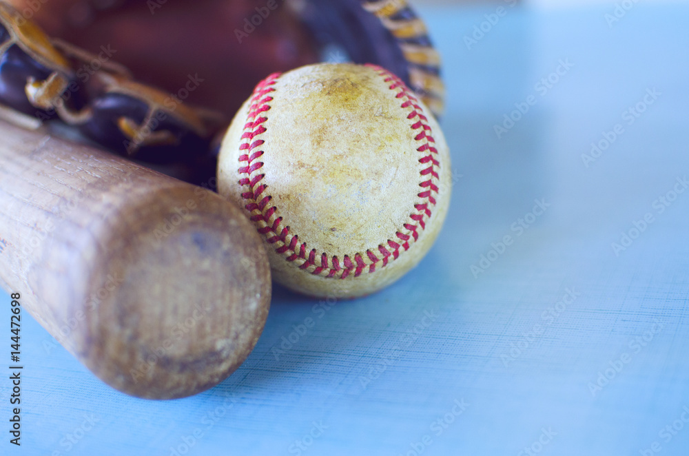 Wooden baseball bat, ball and brown leather mitt with blue background. Wooden baseball bat, ball and brown leather mitt with blue background.