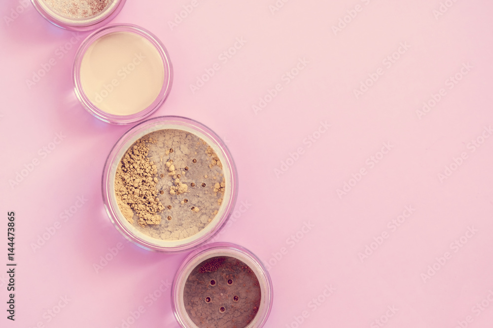 Mineral beauty makeup kit, loose powder, bronzer, concealer, highlighter on pink colored background. Top view. Copyspace Mineral beauty makeup kit, loose powder, bronzer, concealer, highlighter on pink colored background. Top view. Copyspace
