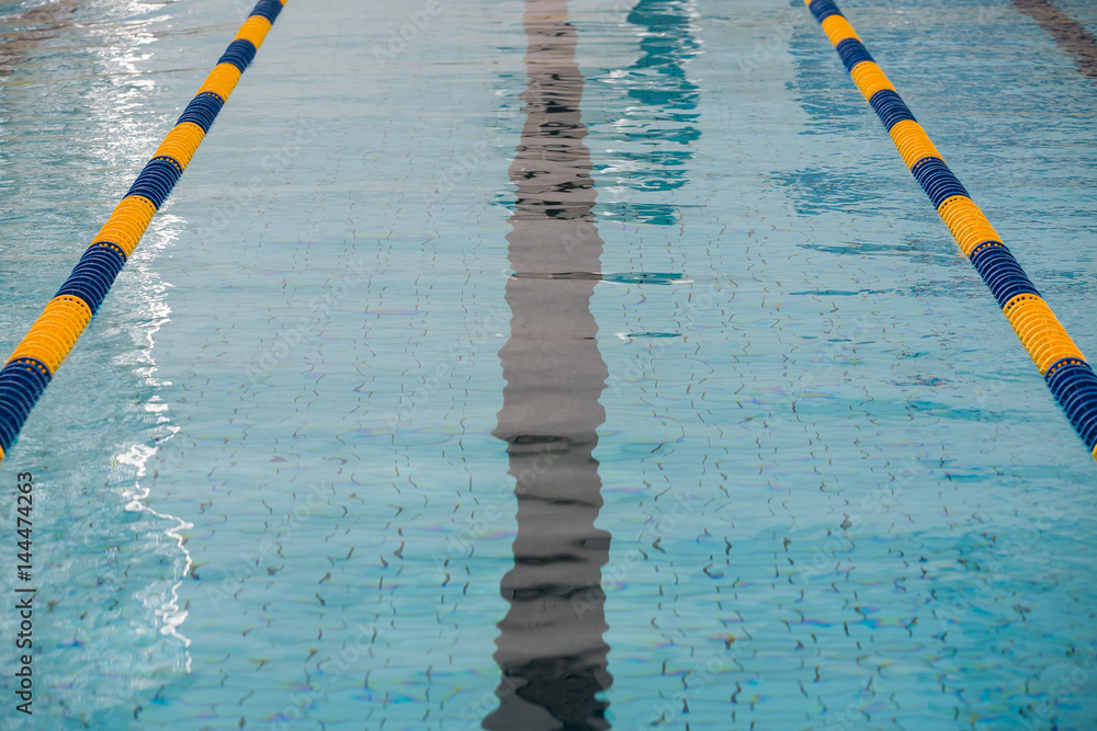 Obraz premium The view of an empty public swimming pool indoors. Lanes of a competition swimming pool. Sport concept