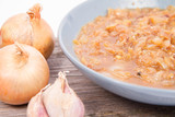 Onion soup on a wooden background with some onions and garlic