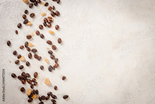 Morning. Food background. Grains of coffee and brown cane sugar on a white stone table. Top view copy space