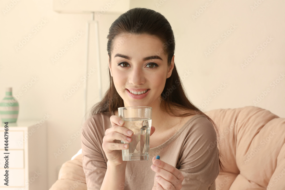 Beautiful young woman taking pill at home Beautiful young woman taking pill at home