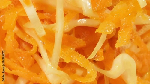 Vegetable salad of carrot and cabbage in white plate on wooden background close up. Vegetarian healthy salad in vegetable oil