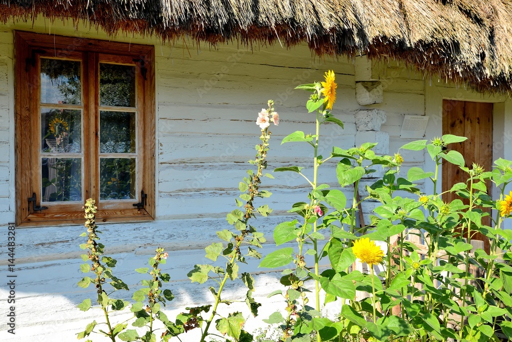 flowers on the old wooden hut covered with thatch village