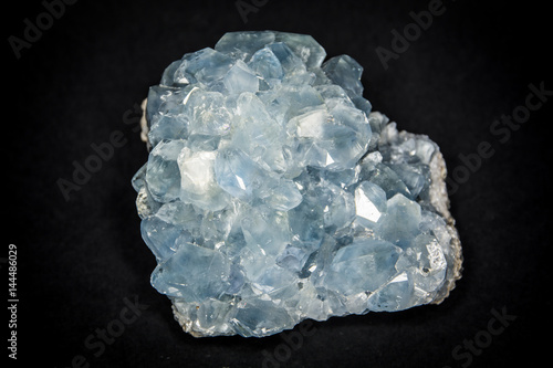 Fotografie A celestite or celestine stone placed on black background, isolated