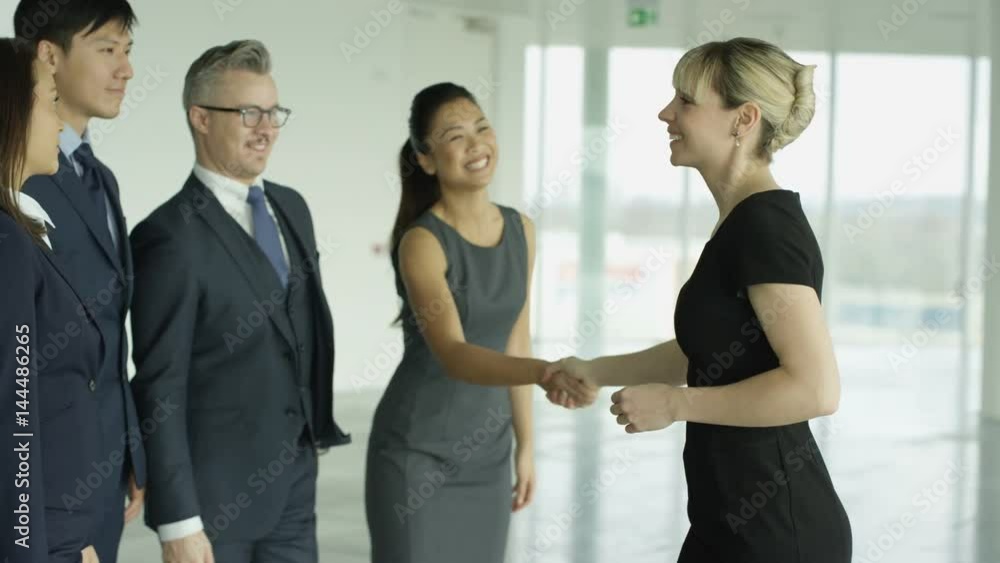 Business teams meet & shake hands in large modern office building Business teams meet & shake hands in large modern office building