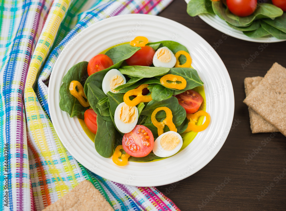Healthy food. Fresh salad of spinach with cherry tomatoes, bell pepper and quail eggs Healthy food. Fresh salad of spinach with cherry tomatoes, bell pepper and quail eggs