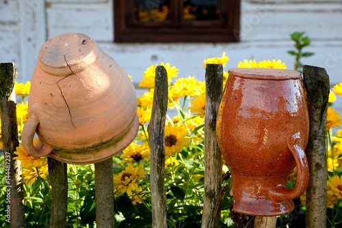 Obraz na płótnie rural landscape with clay pots and flowers on the fence w salonie