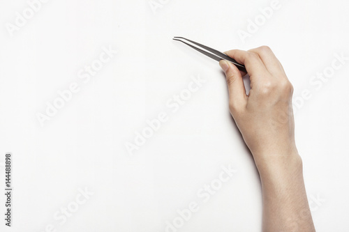 woman(female) hand hold a pincers isolated white.