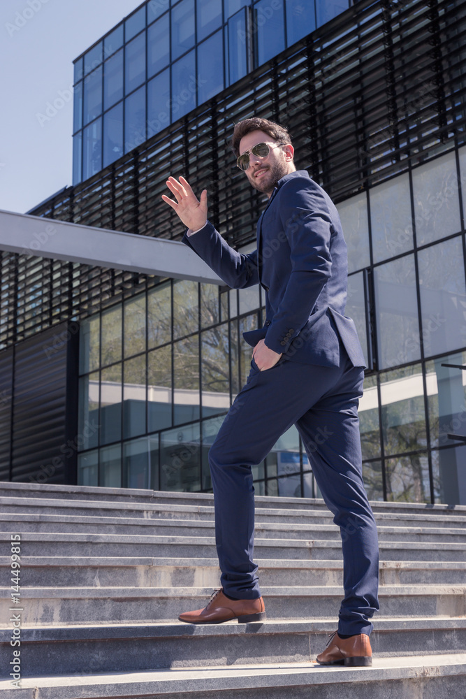 one young man, suit hand waving, back rear view one young man, suit hand waving, back rear view