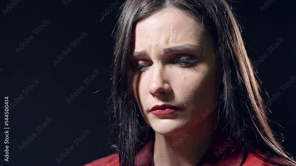 Close-up sad face of young beautiful girl in a dark room Close-up sad face of young beautiful girl in a dark room