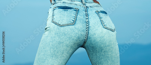 Stockfoto Pretty women 's ass in tight jeans on blue background. Fit female  butt in jeans. Young sexy woman is wearing blue jeans. Rear view. Sexy  woman in skinny denim pants, women '