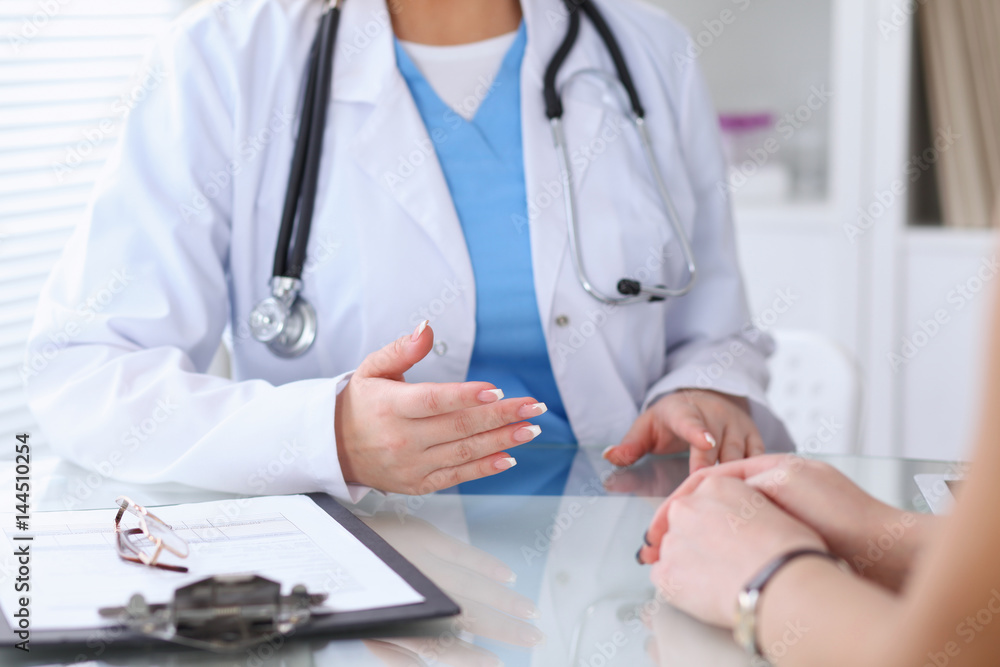 Close up of a doctor and patient hands discussing something while sitting at the table . Medicine and health care concept Close up of a doctor and patient hands discussing something while sitting at the table . Medicine and health care concept