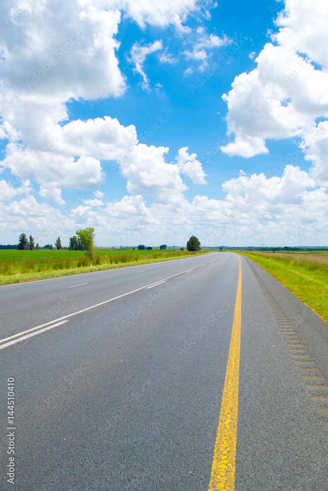 Long road ahead under a blue sky