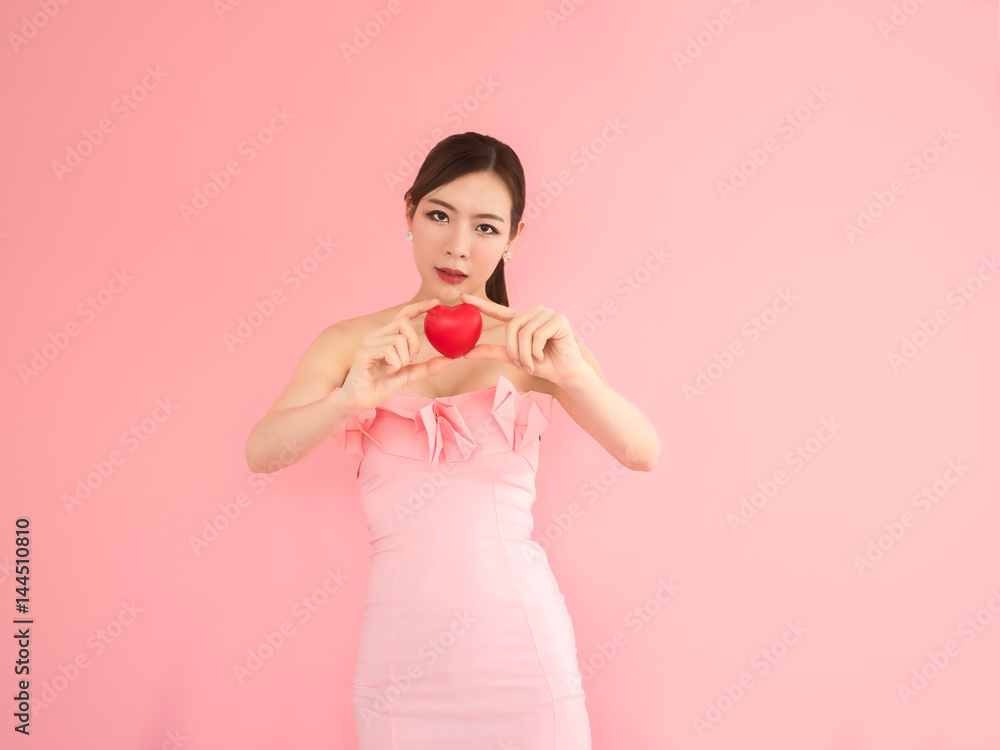 beautiful woman holding mini heart,fashion girl on pink background beautiful woman holding mini heart,fashion girl on pink background
