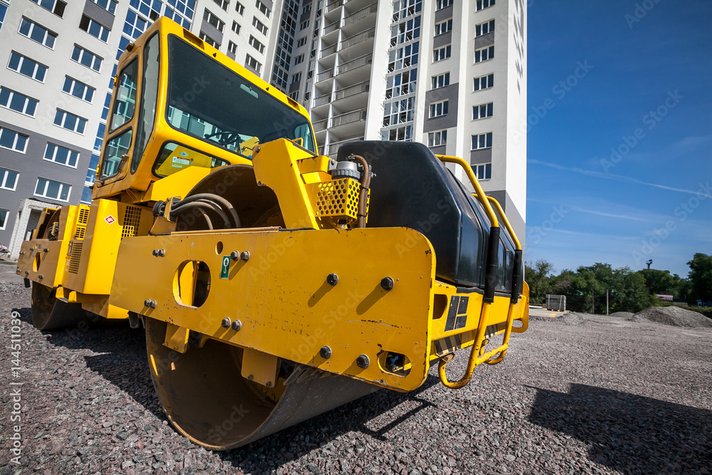 Yellow road roller works on construction site construction site