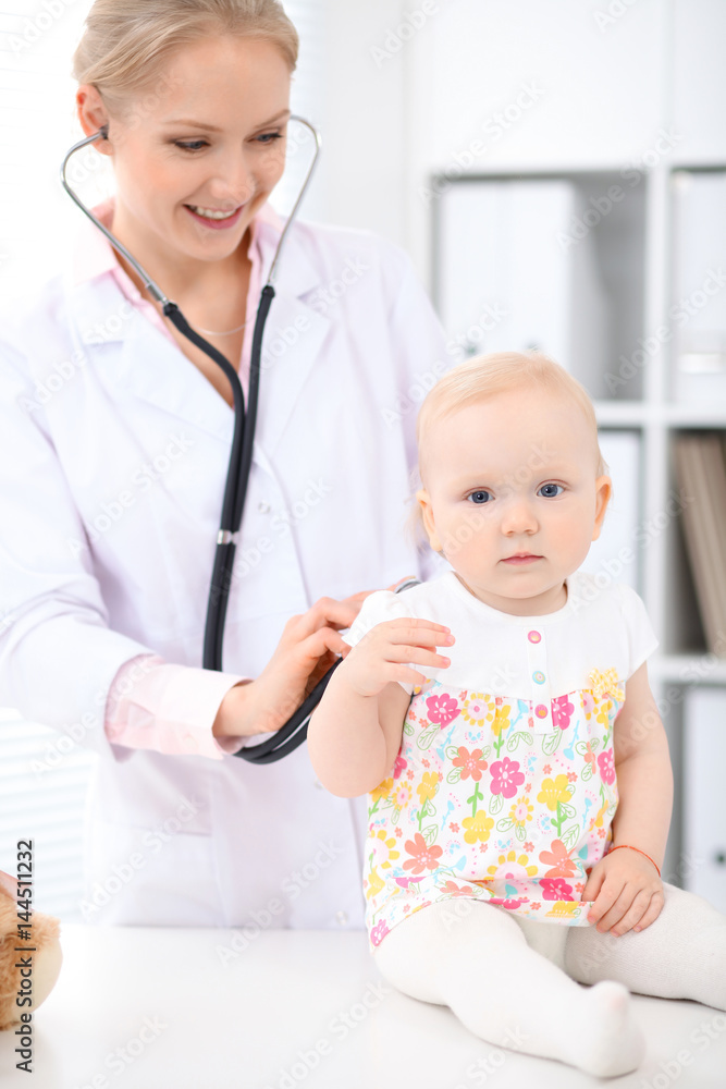 Pediatrician is taking care of baby in hospital. Little girl is being examine by doctor with stethoscope. Health care, insurance and help concept. Pediatrician is taking care of baby in hospital. Little girl is being examine by doctor with stethoscope. Health care, insurance and help concept.
