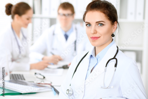 Wallpaper Mural Happy doctor woman  with medical staff at the hospital sitting at the table and discussing medical history Torontodigital.ca