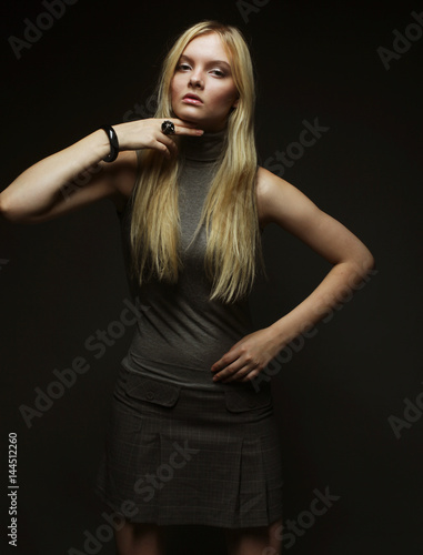 Portrait of beautiful young blonde girl in black dress. 