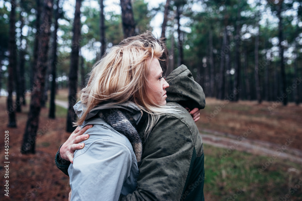 A loving guy with a girl is walking through the woods in the rain. A loving guy with a girl is walking through the woods in the rain.
