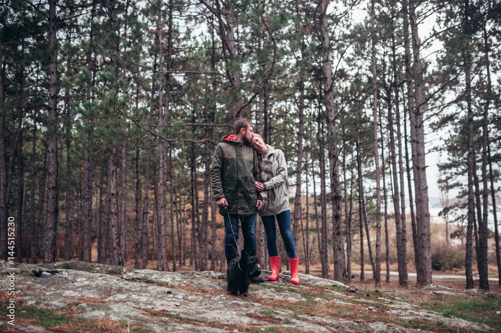A loving guy with a girl is walking through the woods in the rain. A loving guy with a girl is walking through the woods in the rain.