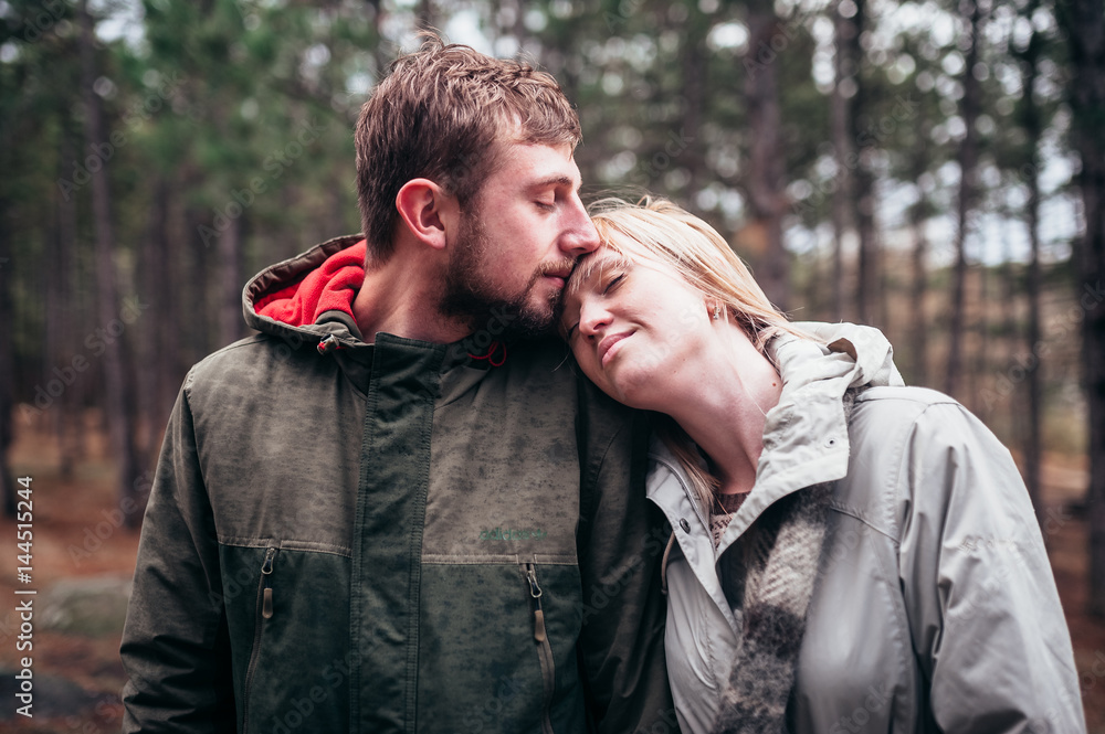 A loving guy with a girl is walking through the woods in the rain. A loving guy with a girl is walking through the woods in the rain.