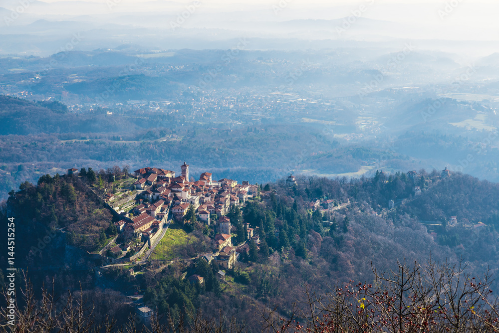 Fototapeta premium Sacro Monte w Varese, Varese, Włochy. Widok z lotu ptaka. Wieś zwana także Santa Maria del Monte, w 2003 roku wpisana na listę światowego dziedzictwa UNESCO. Po prawej, święta droga z sześcioma kaplicami