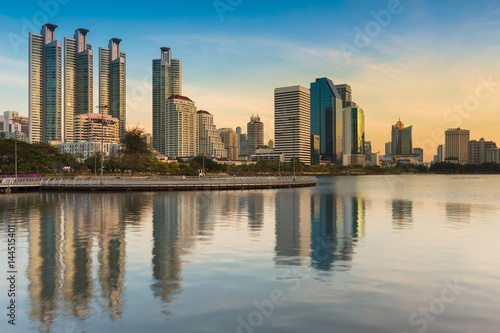City office building with water reflection in public park, Bangkok city downtown Thailand © pranodhm