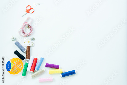 Sewing accessories, tools ,colorful spools, needle and measuring tapeof thread with scissors isolated on white background, top view