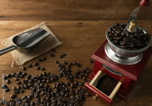 coffee beans in grinder, on table wood background