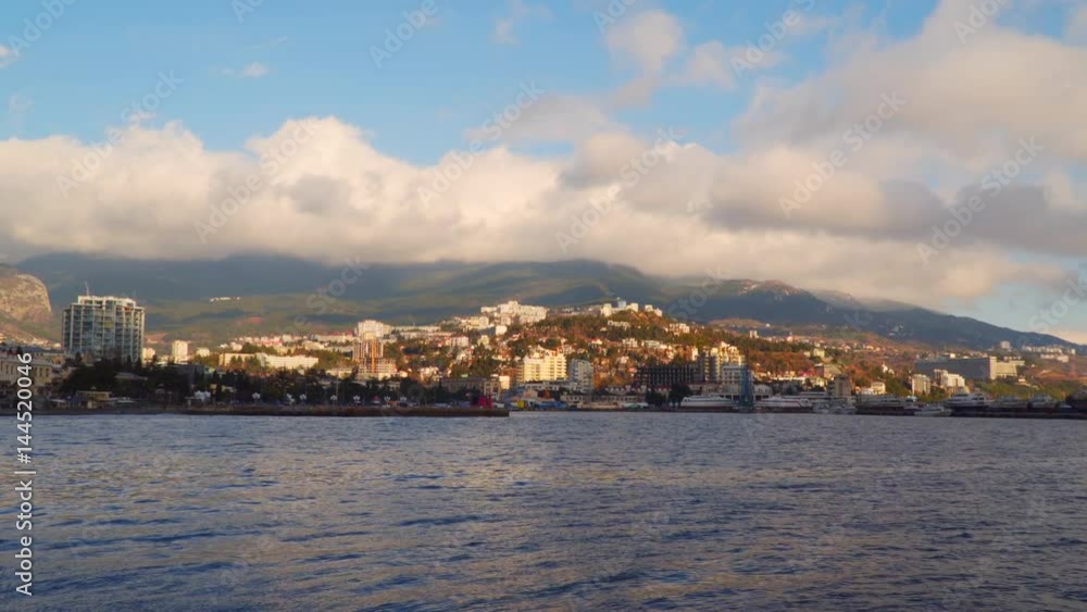 View of the coastal city at dawn. The city is located at the foot of the mountains in the clouds. Yalta Crimea View of the coastal city at dawn. The city is located at the foot of the mountains in the clouds. Yalta Crimea