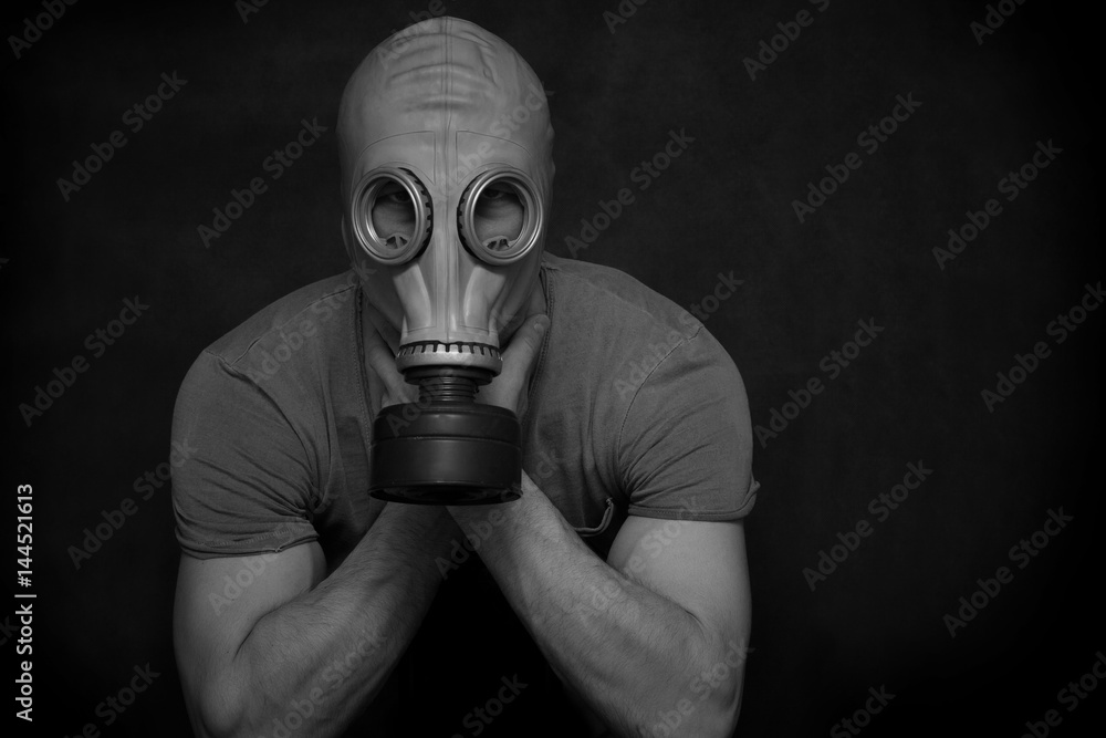 The man in a gas mask on a black background. Conceptual photo, black and white photography. Free space for text