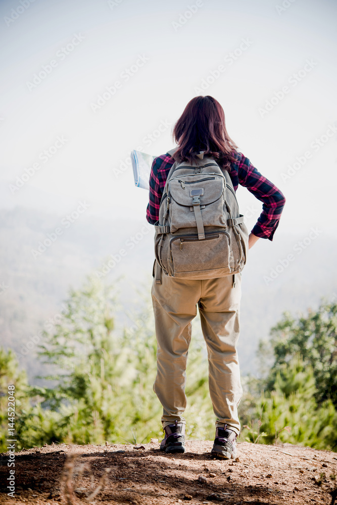 Naklejka premium Hiker with backpack standing on the mountain