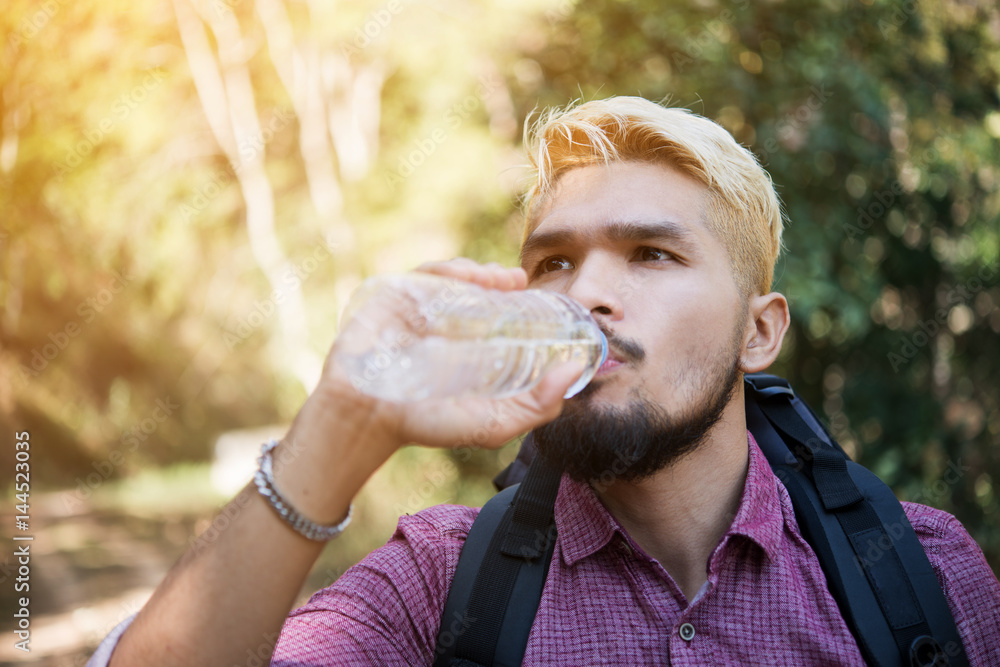 Obraz premium Men drinking water in the forest.