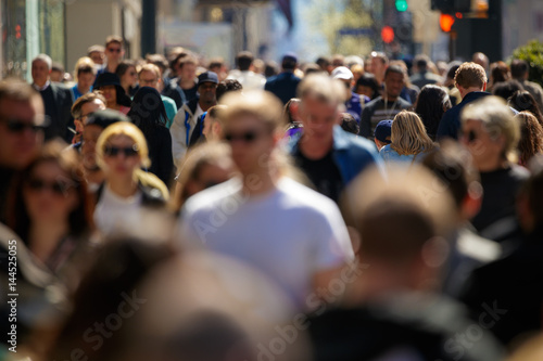 Crowd of people walking street in city