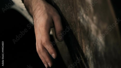 extremelly close up shot of man drumming out a beat on an arabic percussion drum named Bendir at home. Shot on black background photo