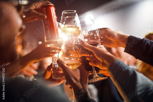Cheerful friends clinking glasses above dinner table. Alcohol and toasting, party and celebration theme. Congratulations on the event.