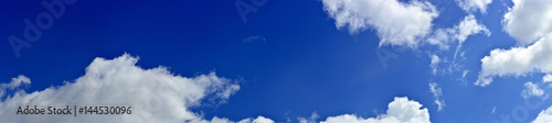 Panorama of spring, summer clouds on a blue sunny sky, background.