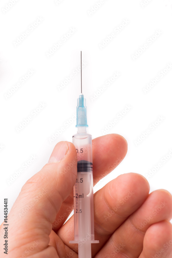 Hand holding a syringe Hand holding a syringe