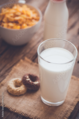 milk, cookies and bowl of cereal on wooden background