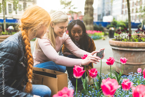 Girls taking photo of tulip flowers in London © william87