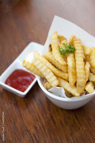 French fries in a bowl on a wooden table