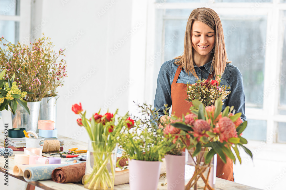 Florist at work: the female hands of woman making fashion modern bouquet of different flowers Florist at work: the female hands of woman making fashion modern bouquet of different flowers
