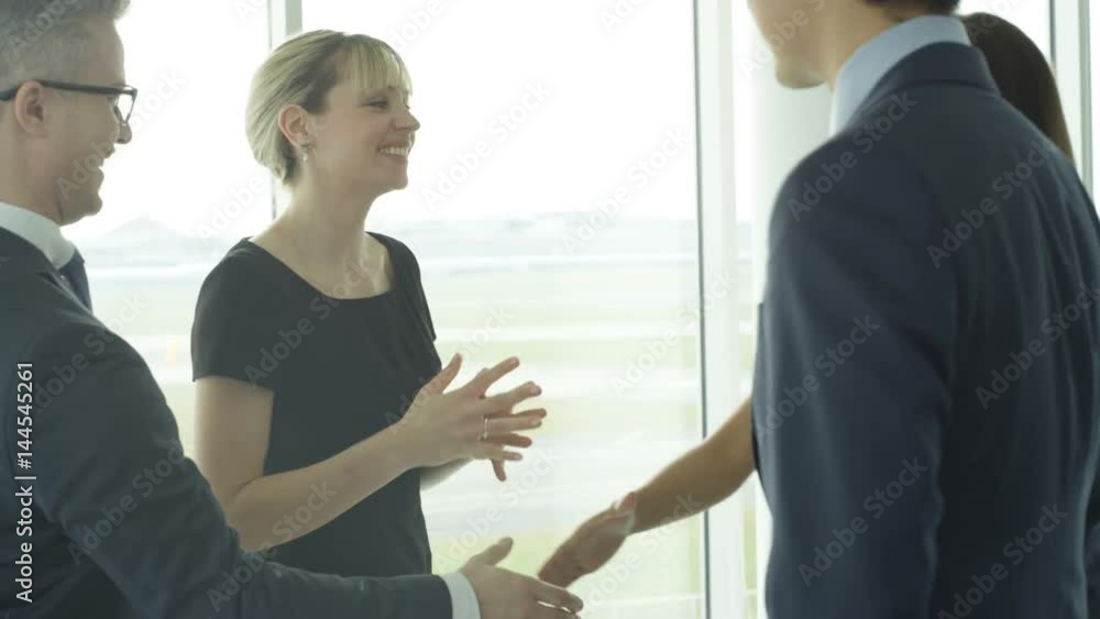 Business teams meet & shake hands in large modern office building Business teams meet & shake hands in large modern office building