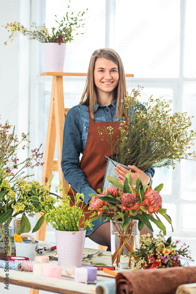 Florist at work: the young girl making fashion modern bouquet of different flowers Florist at work: the young girl making fashion modern bouquet of different flowers