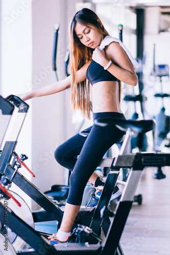 Sport young woman on a stationary bike in the gym