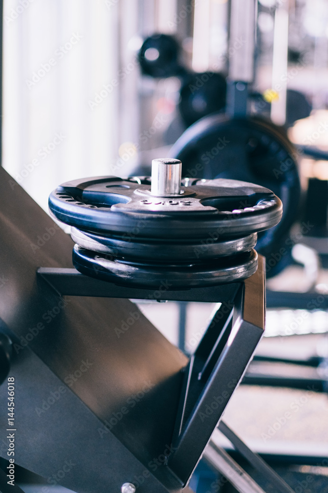 Obraz premium Set of metal barbells disks on barbbell holder in the fitness gym