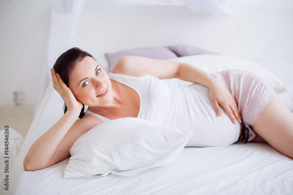 Young pregnant woman in the bedroom Young pregnant woman in the bedroom