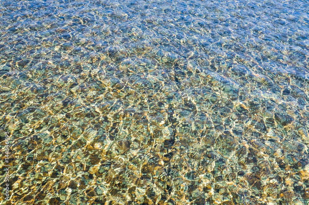 The water in the pool has a tile bottom tile glittering in the sun. Background, texture